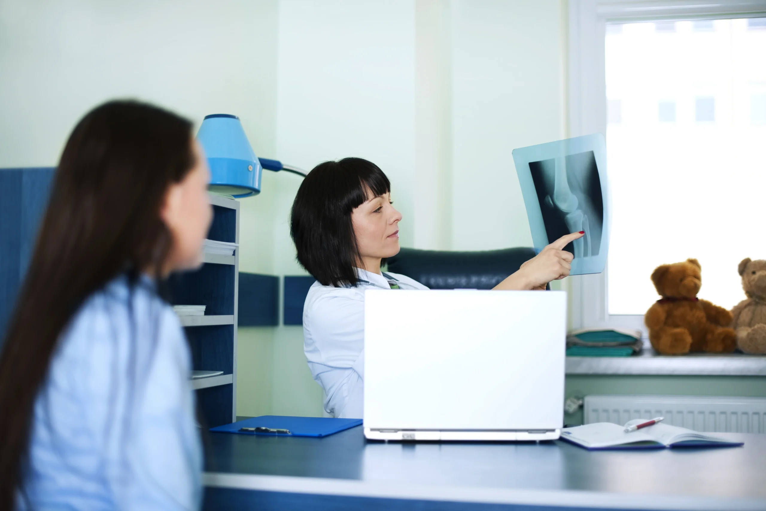 The doctor is showing the x-ray results to the patient.